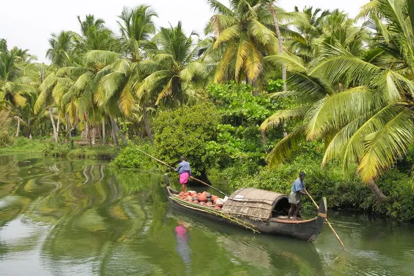 Indian men in traditional boat float on Kerala backwaters near Alappuzha in Kerala, India.