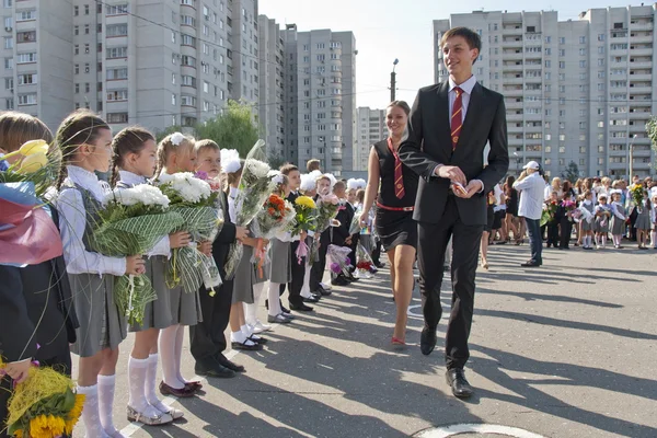 Alunos sênior recebem os primeiros formadores na cerimônia tradicional em 1 de setembro na Rússia . — Fotografia de Stock