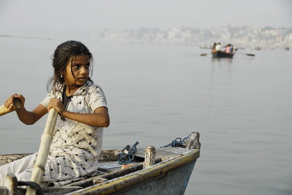 Indian girl steers boat on Ganga river in Varanasi, India. — Stock Photo, Image