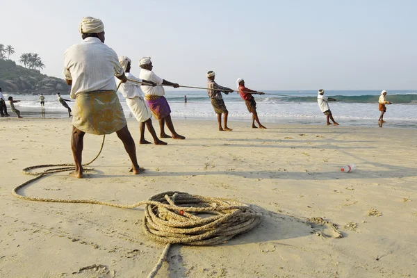 Pescadores indianos puxam seu cerco para fora do mar em Kovalam, Índia . — Fotografia de Stock