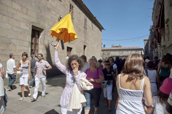 Guía turística espera a sus turistas en una calle llena de cuervos en Santiago, España . —  Fotos de Stock