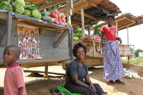 Ugandian kvinnor säljer grönsaker på väg nära masindi, uganda. — Stockfoto