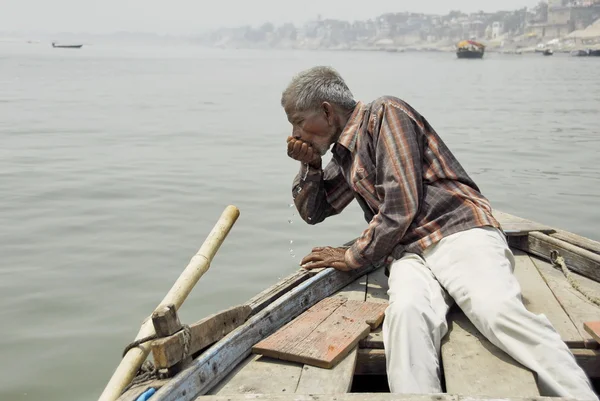 Barquero indio bebe agua del río Ganga en Varanasi, India . — Foto de Stock
