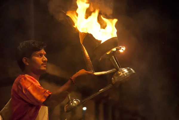Homem indiano realiza rotação com uma "lâmpada de fogo Aarti" durante a noite Ganga Aarti em Varanasi, Índia . — Fotografia de Stock