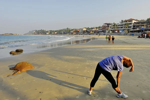 Batı turist Kerala, Hindistan kovalam plajda erken sabah egzersizleri yapar.