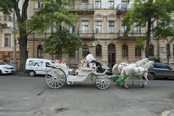 Τουρίστες βόλτα σε ένα άλογο μεταφορά κατά μήκος της οδού σε Οδησσός, Ουκρανία. Φωτογραφία Αρχείου