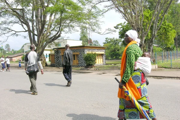 Rwandyjski kobieta idzie na ulicy z jej dziecko w gisenyi, rwanda. — Zdjęcie stockowe