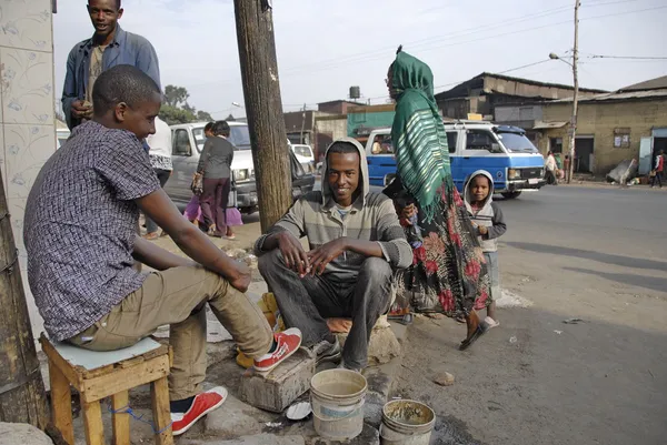 Shoe shiner limpa sapatos de seu cliente em Mercato em Addis Abeba, Etiópia . — Fotografia de Stock