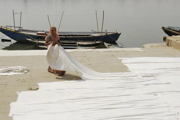 Indian woman lays out clothes for drying on Ganges's bank  in Varanasi, India. — Stock Photo, Image