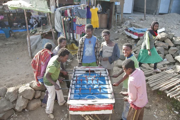 Meninos etíopes jogar jogo de hóquei de mesa em uma rua em Debark, Etiópia . — Fotografia de Stock