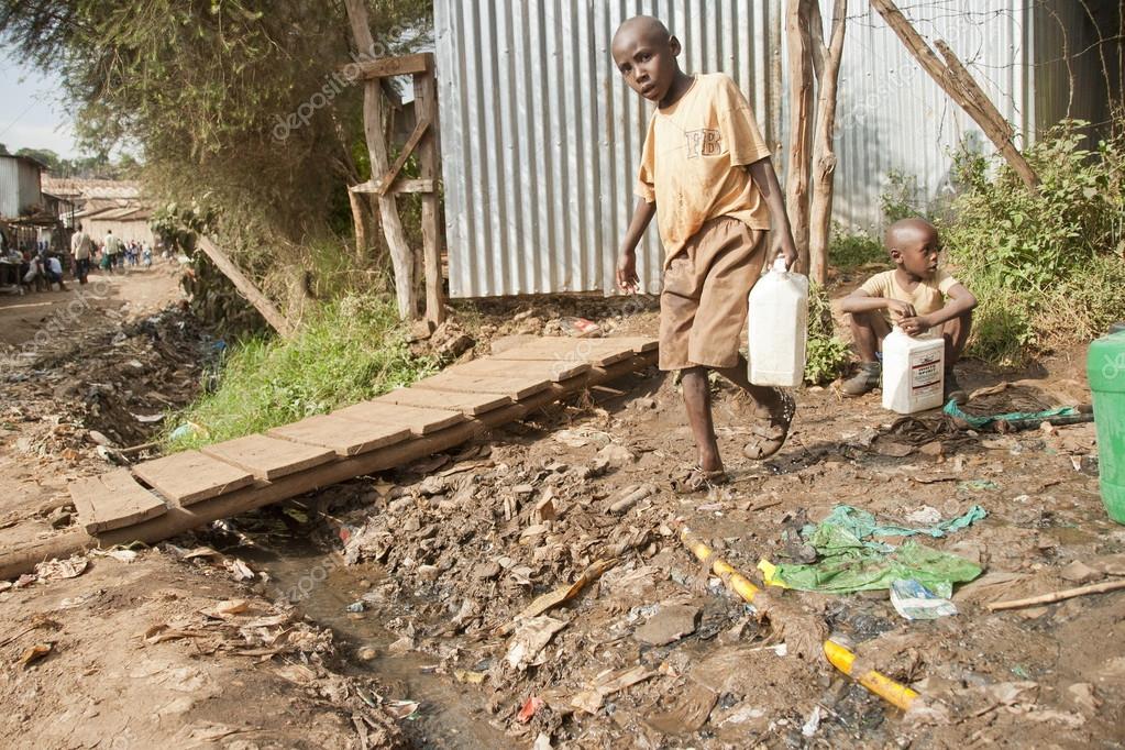 Boys take a water for drinking on a street in Kibera, Nairobi, Kenya