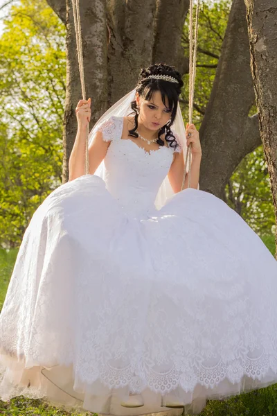 Porträtt av en vacker brud i vit brudklänning som sitter på — Stockfoto