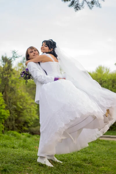 Sposo e sposa in un parco. abito da sposa. Bouquet da sposa — Foto Stock
