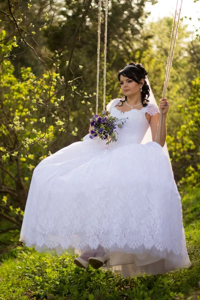 Retrato de una hermosa novia en vestido de novia blanco sentado en —  Fotos de Stock