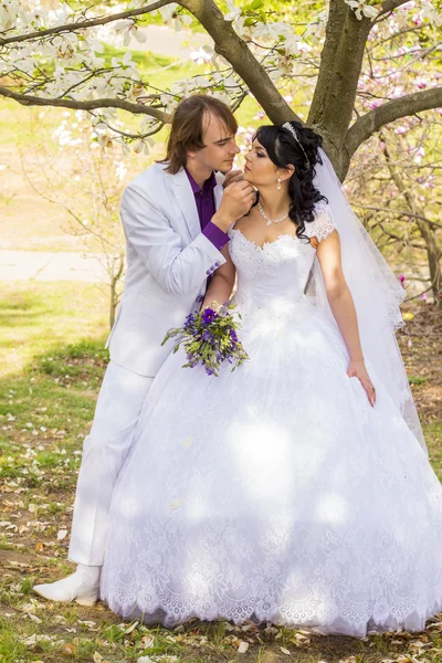 Bride and groom with a bouquet of kisses on the nature — Stock Photo, Image