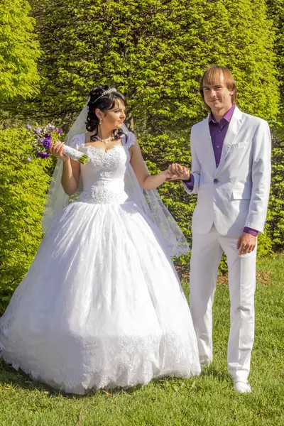 Elegante bruid en bruidegom poseren samen buitenshuis op een bruiloft da — Stockfoto