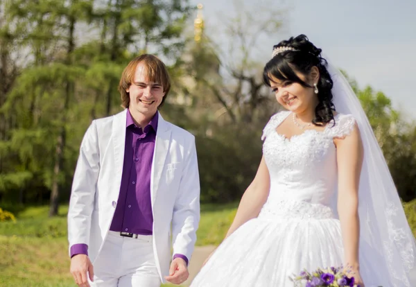 Bella coppia di sposi appena sposati con fiori bouquet a — Foto Stock