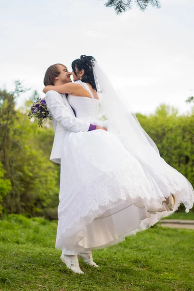 Groom and Bride in a park. wedding dress. Bridal wedding bouquet — Stock Photo, Image