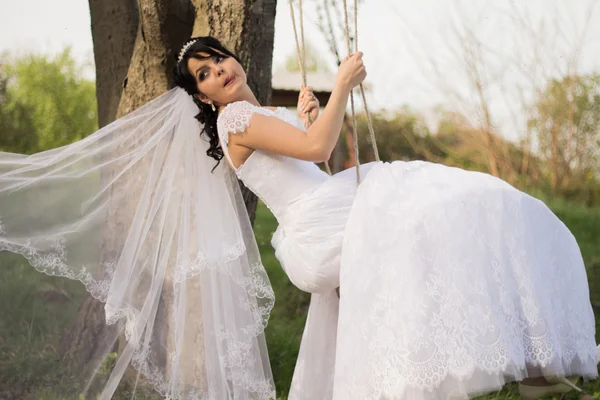 Porträtt av en vacker brud i vit brudklänning som sitter på — Stockfoto