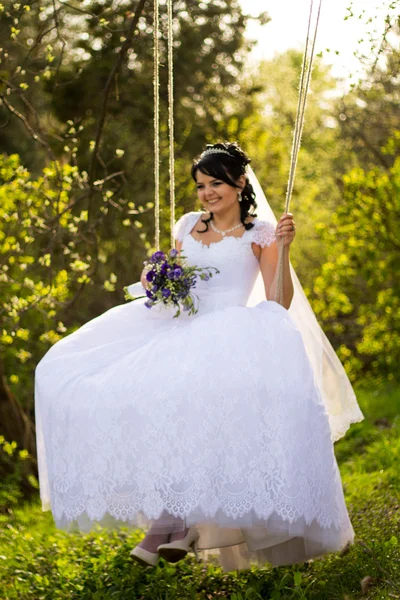 Portrait of a beautiful bride in white wedding dress sitting on — Stock Photo, Image