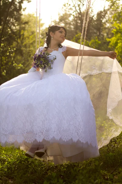 Retrato de una hermosa novia en vestido de novia blanco sentado en —  Fotos de Stock