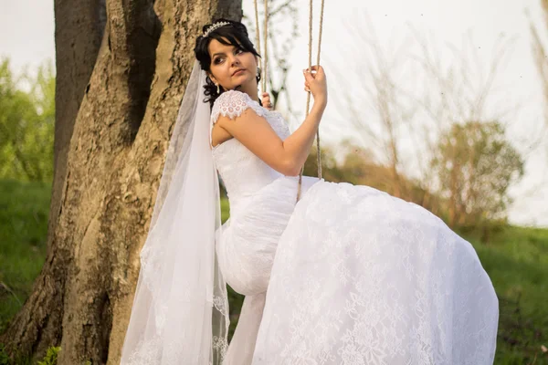 Retrato de una hermosa novia en vestido de novia blanco sentado en —  Fotos de Stock