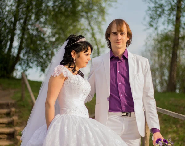 Feliz pareja recién casada de pie en el pequeño puente —  Fotos de Stock
