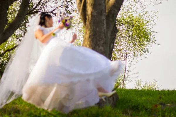 Bride and groom swinging on a swing — Stock Photo, Image