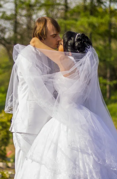 Noiva e noivo com um buquê de beijos na natureza — Fotografia de Stock