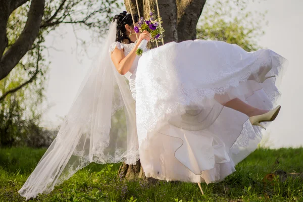 Porträtt av en vacker brud i vit brudklänning som sitter på — Stockfoto