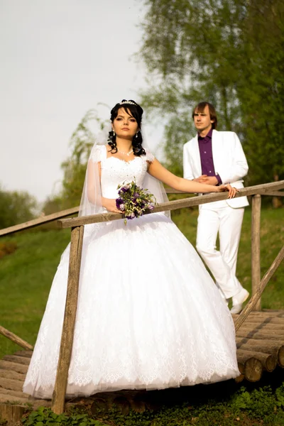 Feliz apenas casado casal de pé na pequena ponte — Fotografia de Stock