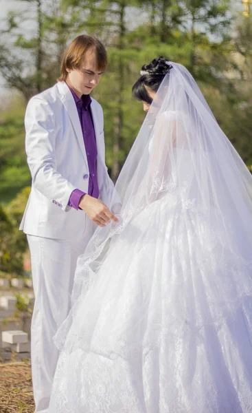 Elegante bruid en bruidegom poseren samen buitenshuis op een bruiloft da — Stockfoto