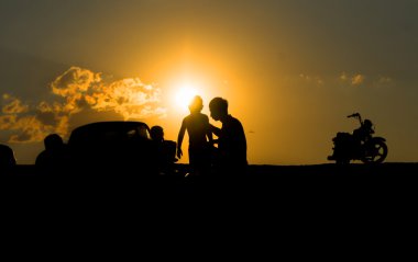 Baba ve çocuk ve motosiklet güneşler karşı Silhouettes