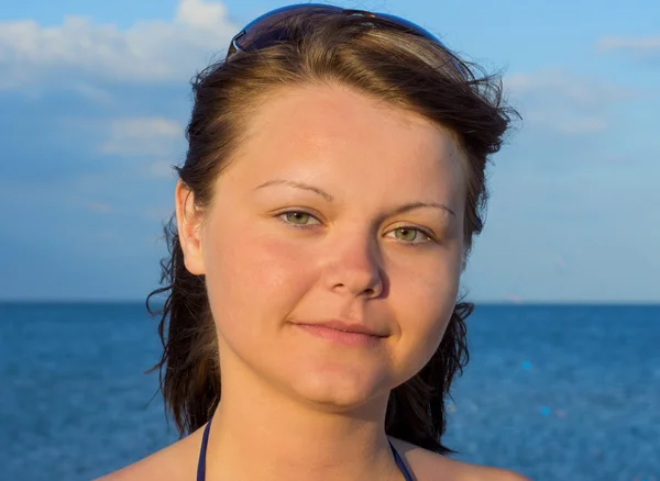 Portret van een mooie jonge vrouw op het strand met een bril — Stockfoto