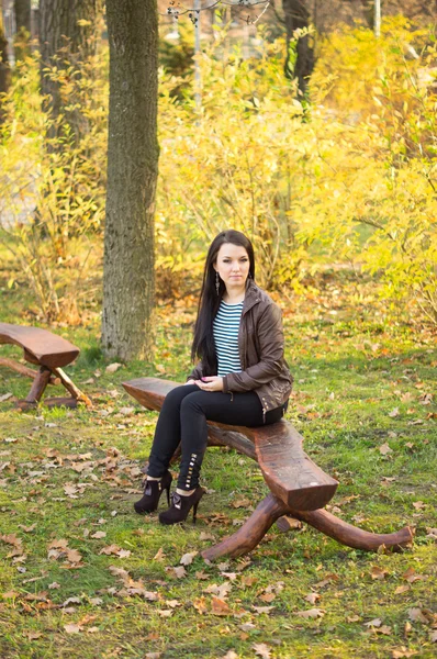 Girl sitting on bench outdoors — Stock Photo, Image