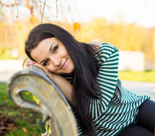 Chica sentada en el banco al aire libre — Foto de Stock