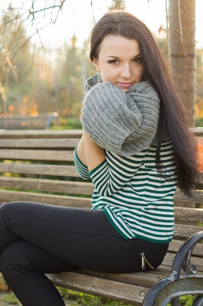 Girl sitting on bench outdoors — Stock Photo, Image