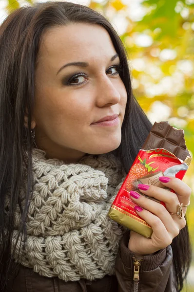 Retrato de una mujer comiendo chocolate al aire libre —  Fotos de Stock