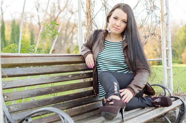 Girl sitting on bench outdoors — Stock Photo, Image