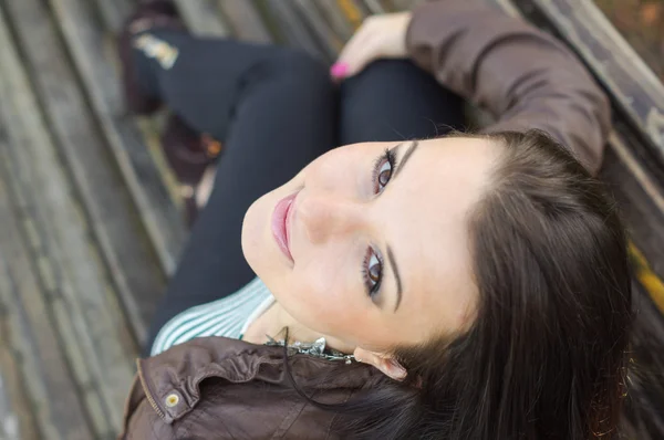 Girl sitting on bench outdoors — Stock Photo, Image