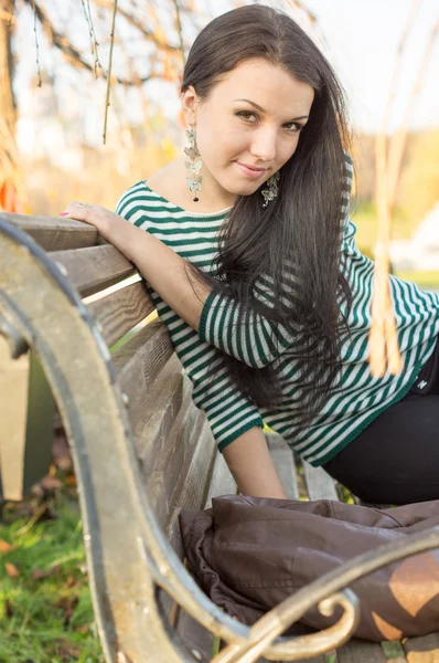 Chica sentada en el banco al aire libre — Foto de Stock