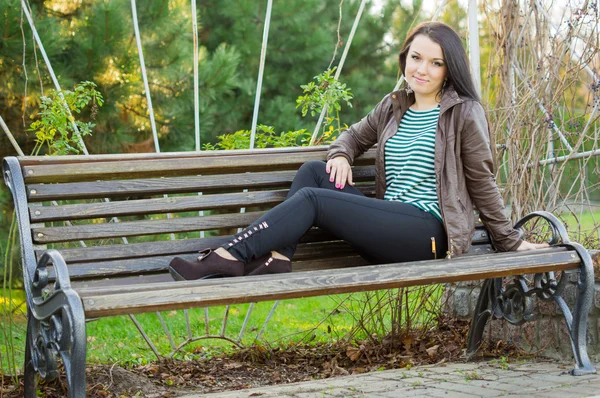 Mädchen sitzt auf Bank im Freien — Stockfoto