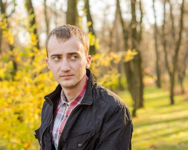 Young handsome man in autumn park — Stock Photo, Image