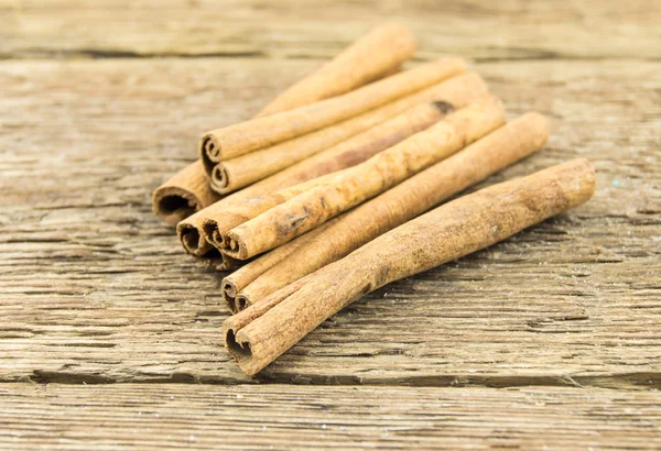 Close up of cinnamon sticks on rustic wood — Stock Photo, Image