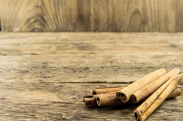 Close up of cinnamon sticks on rustic wood — Stock Photo, Image