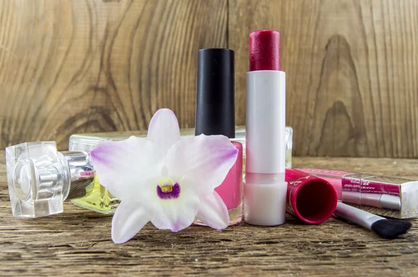 cosmetics and flowers on table on wooden background