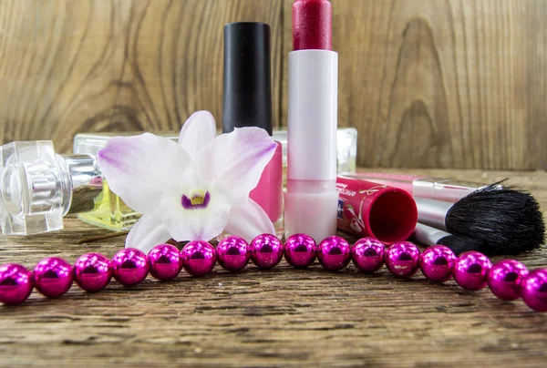 Cosmetics and flowers on table on wooden background — Stock Photo, Image