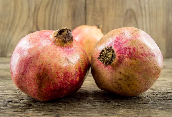 Pomegranate isolated on wooden background — Stock Photo, Image