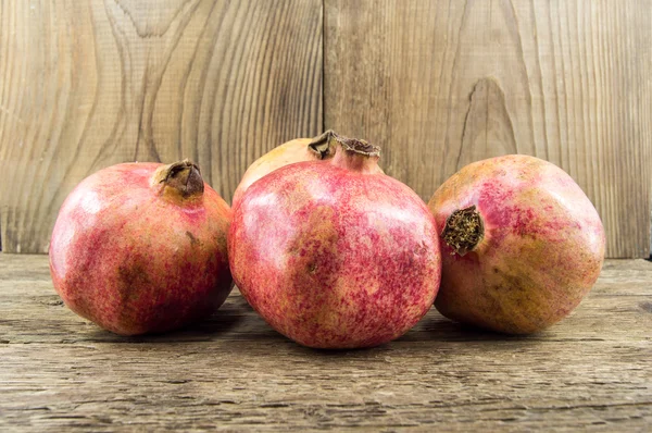 Pomegranate isolated on wooden background — Stock Photo, Image