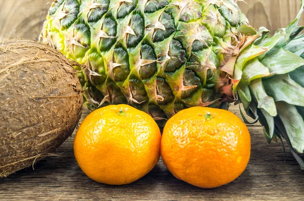 Heerlijke en gearrangeerd tropisch fruit in de houten achtergrond — Stockfoto